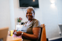 lady knitting at desk smiling