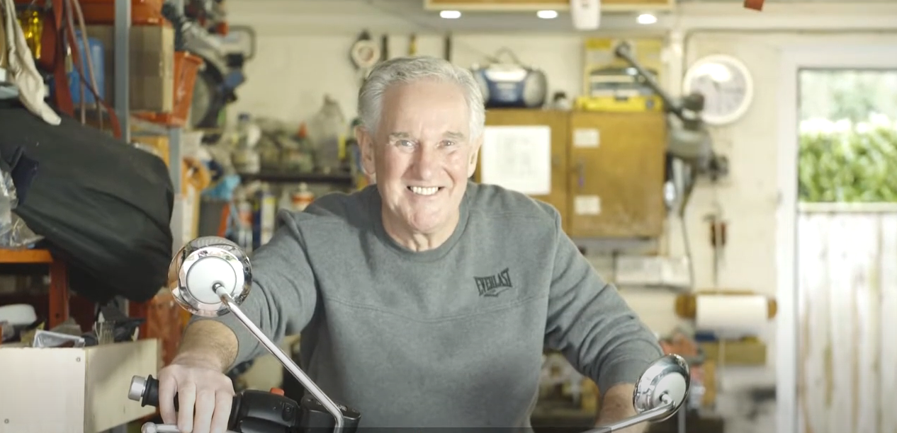 tenant Ron, smiling while sitting on his motorbike