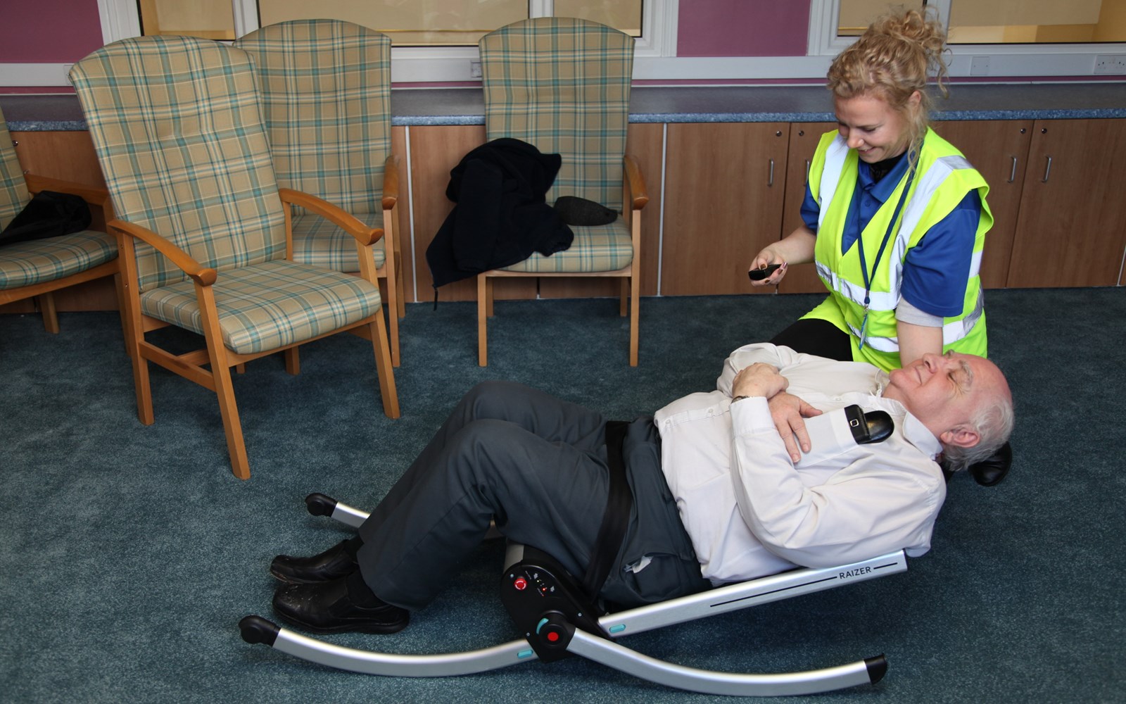 man lying on the floor, being helped up by our lifeline tools for the independent living schemes 