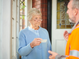 Woman checking I.D of caller at her home 